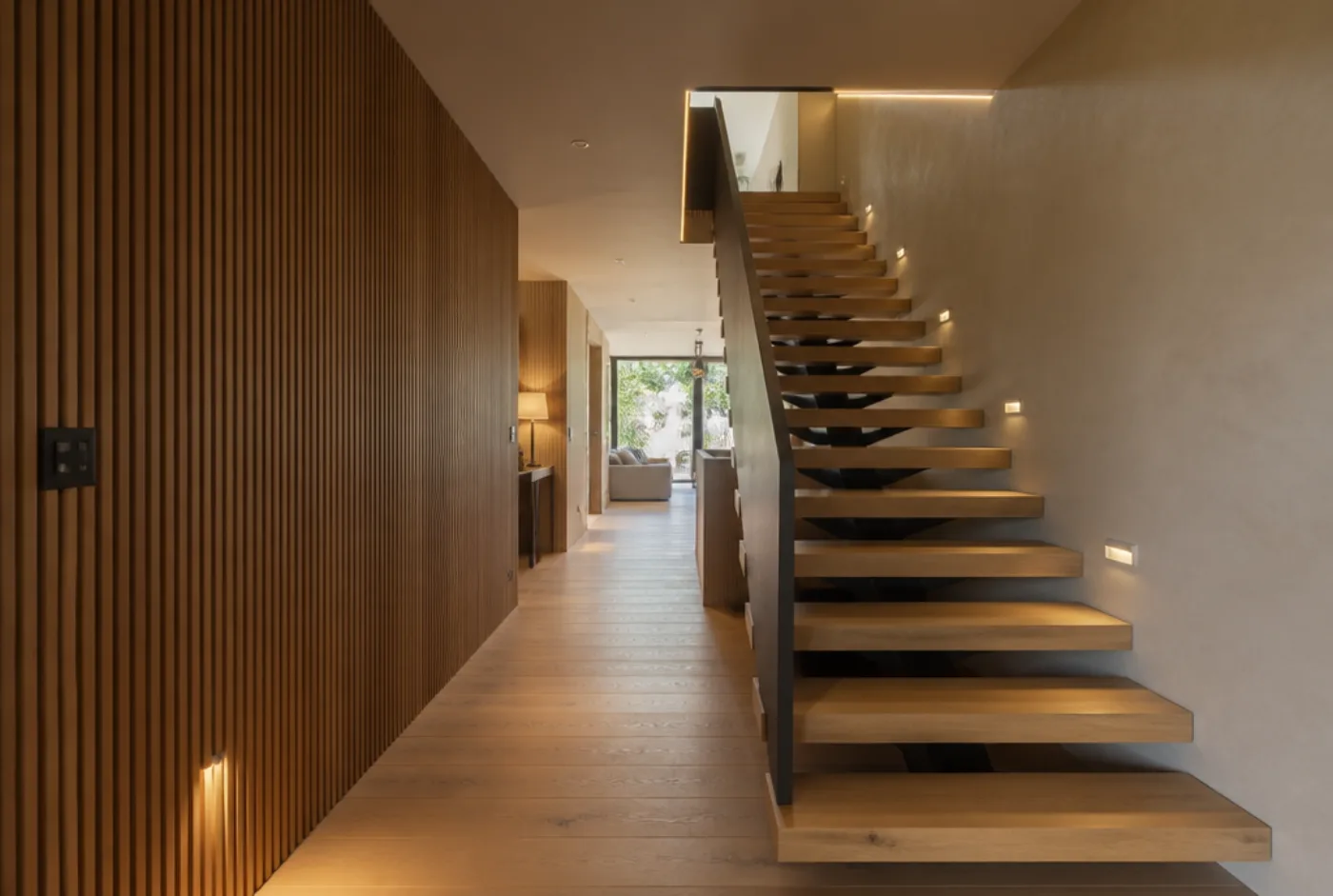 Flur mit Lamellenwand aus Eiche und freitragender Treppe